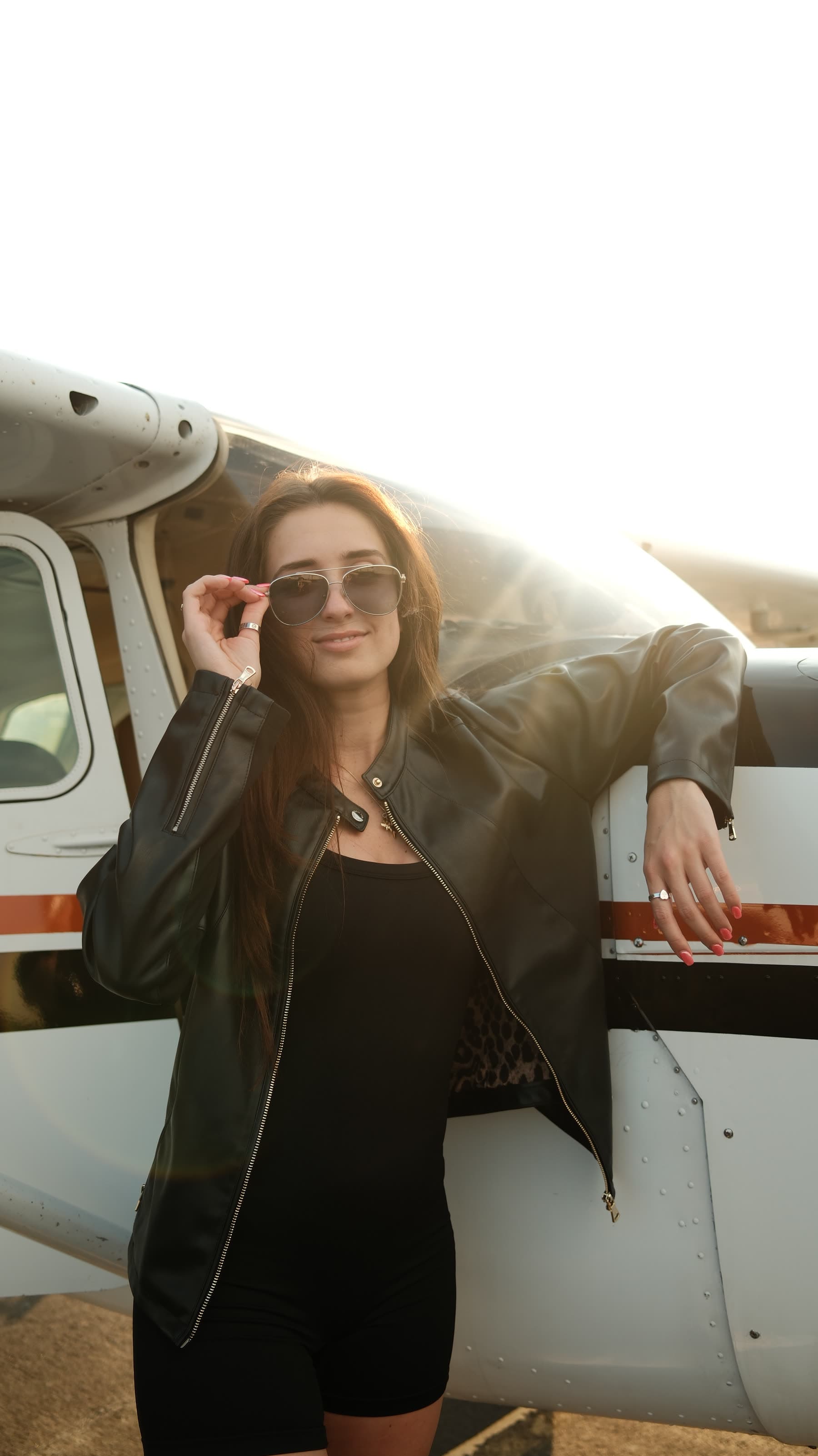 A flight instructor beside her aircraft at golden hour