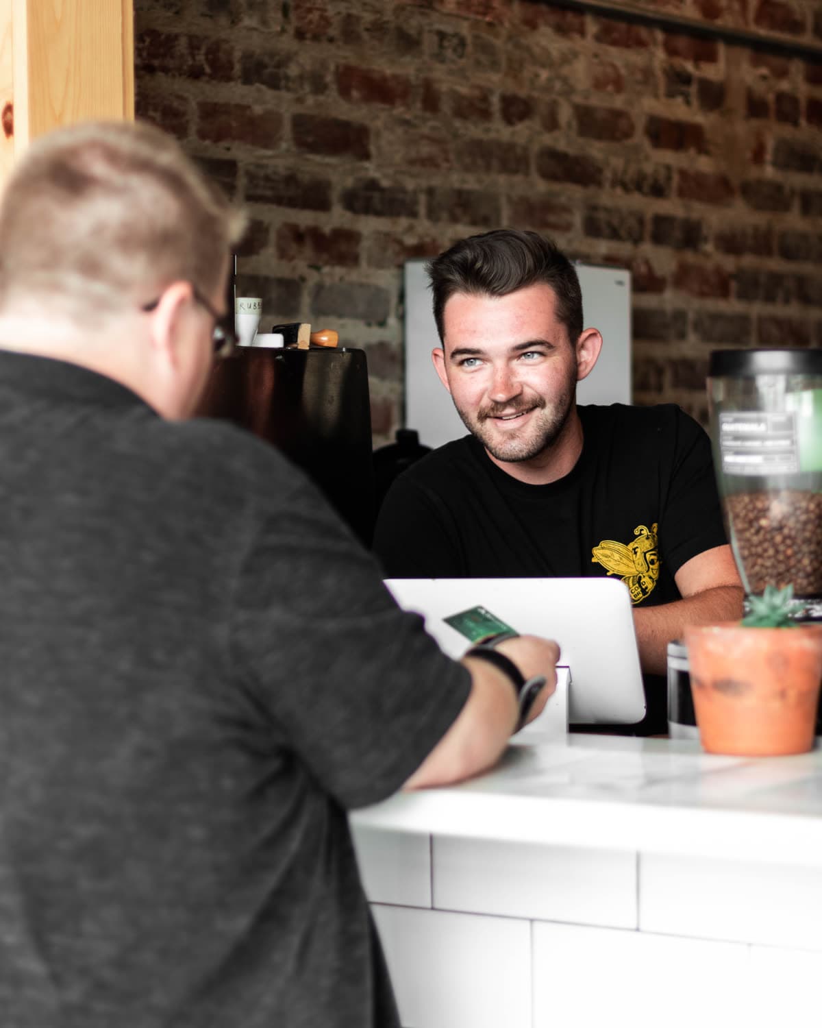A shop owner taking a customer's order at the counter