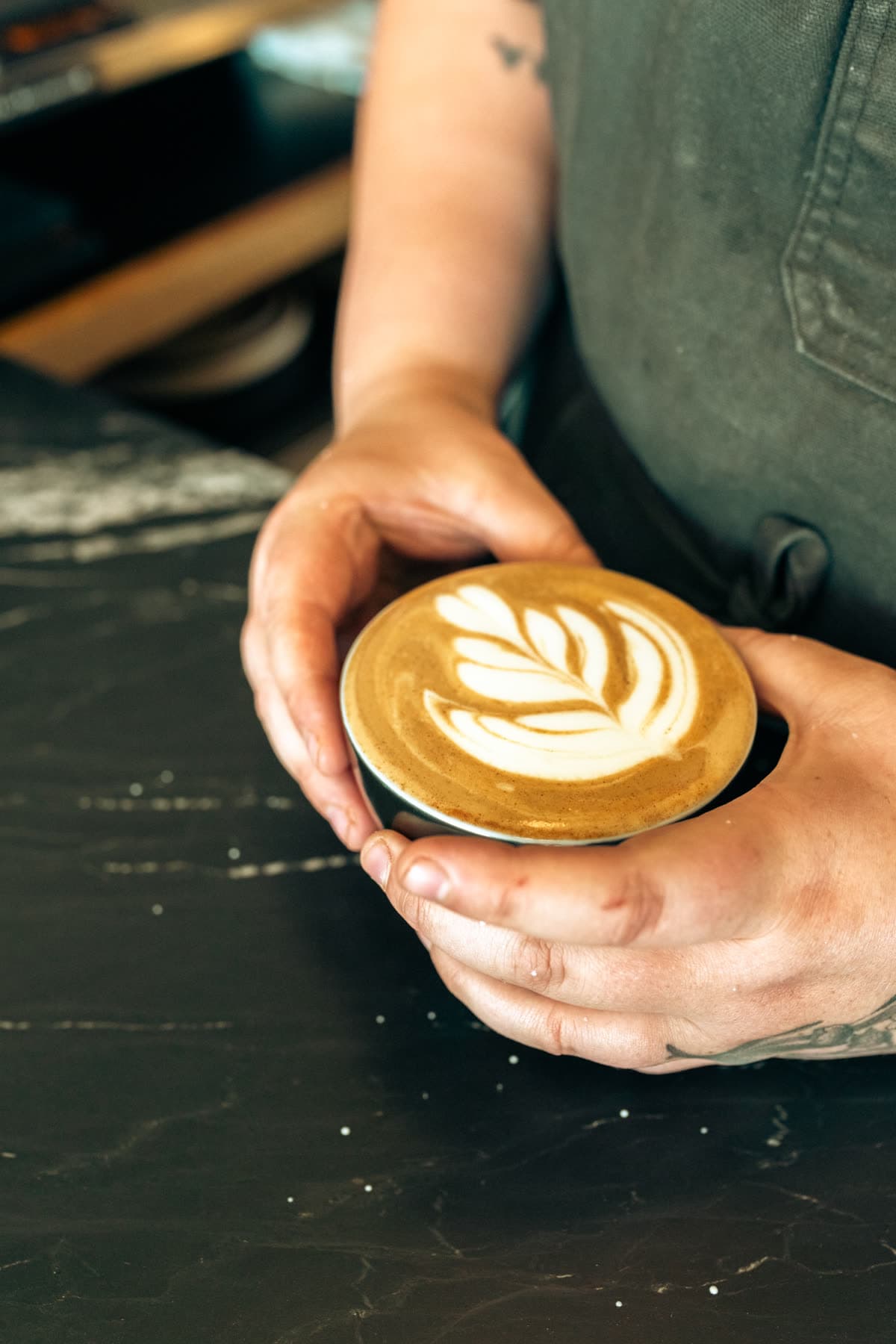 Finished latte art held in two hands