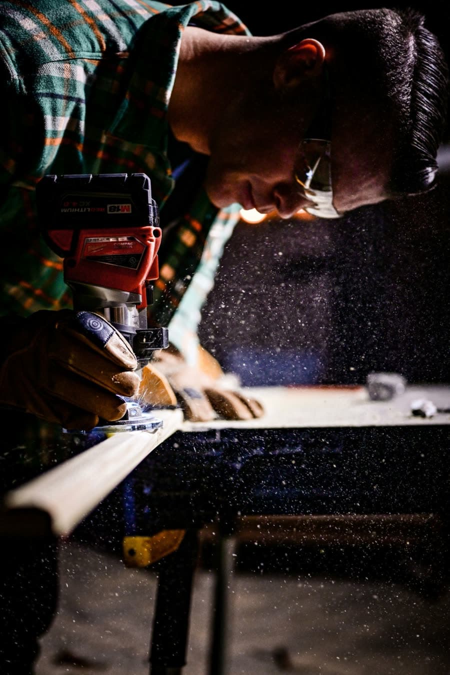 A woodworker running a router along an edge
